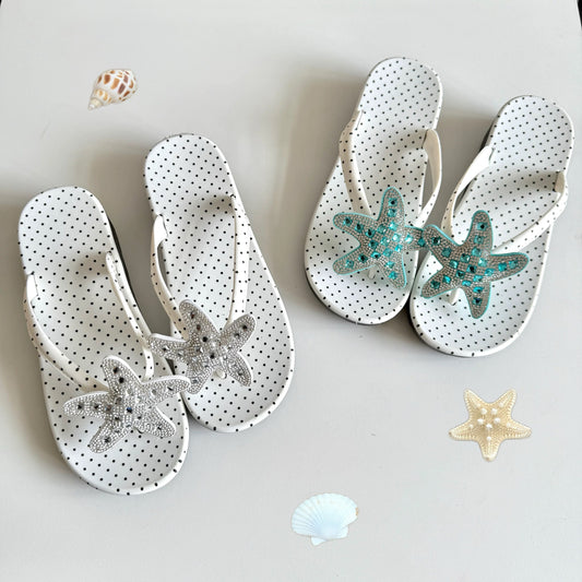 White polka dot flip flops with large jeweled turquoise starfish on sand