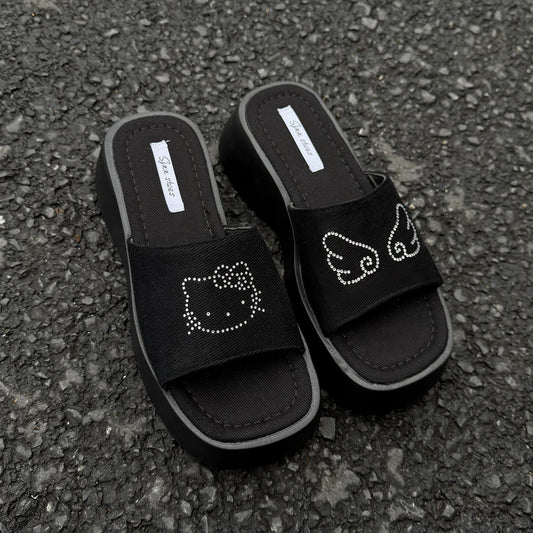 Black platform slide sandals with rhinestone cartoon cat design and chunky sole