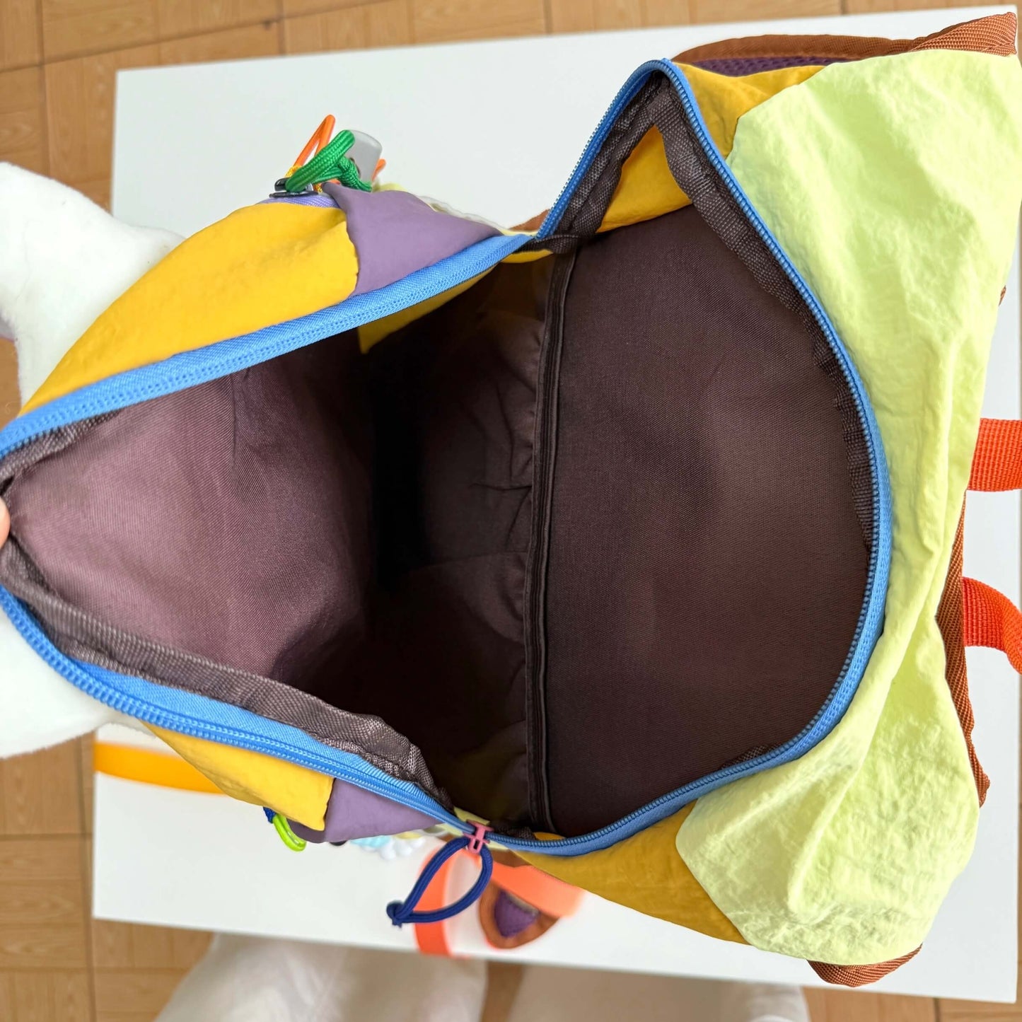 Colorful children's bag with a brown interior on a white surface.