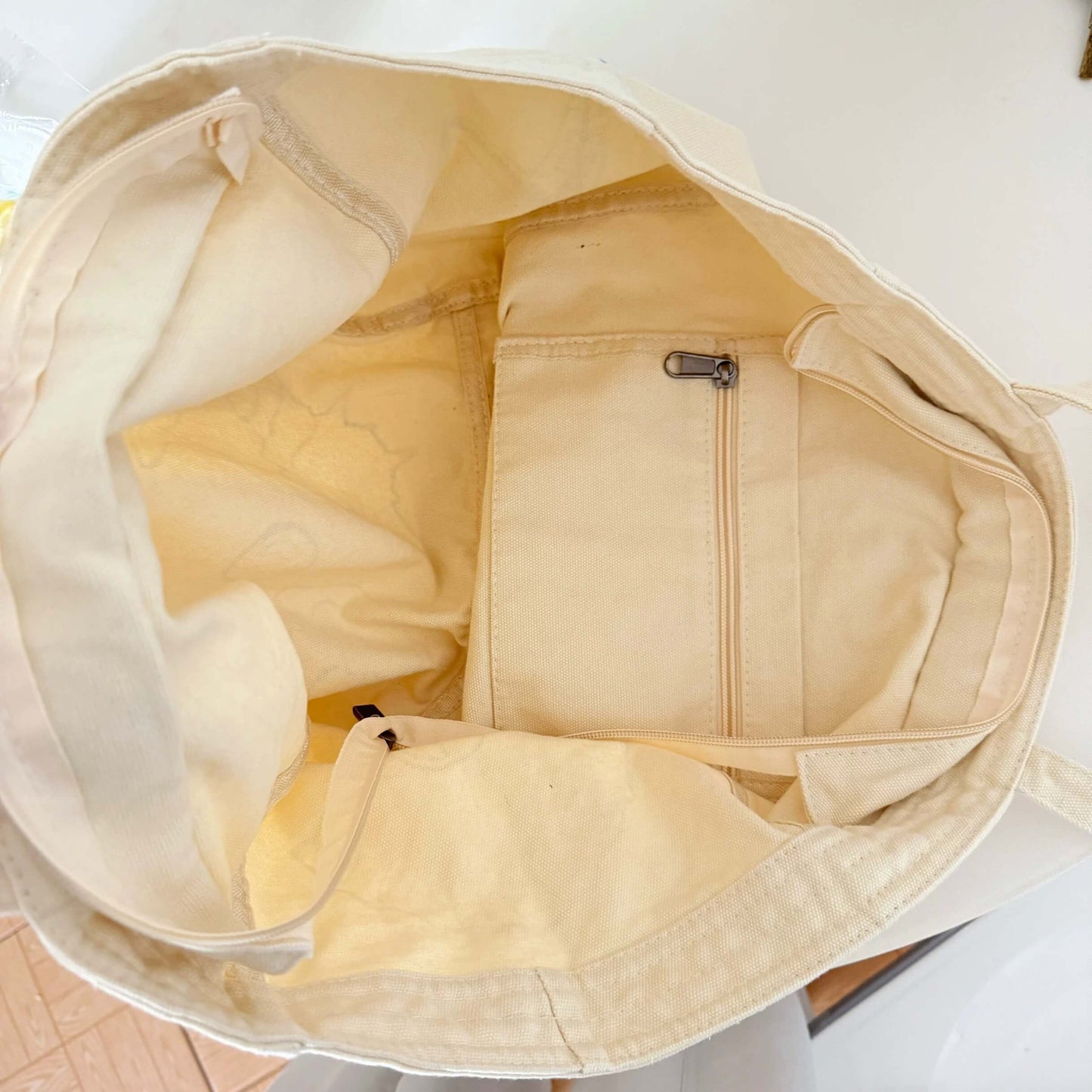 Beige garment bag with a zipper on a white background