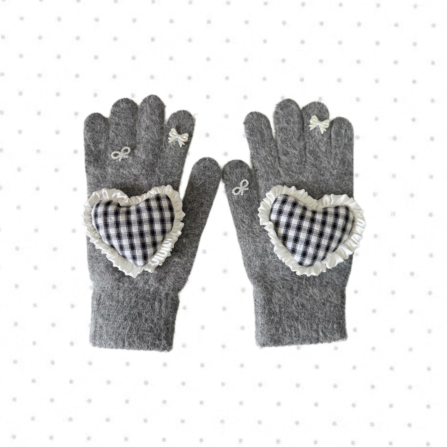 Grey knit gloves with a black and white gingham heart patch, ruffle trim, and white ribbon bows on fingers, coquette aesthetic style.
