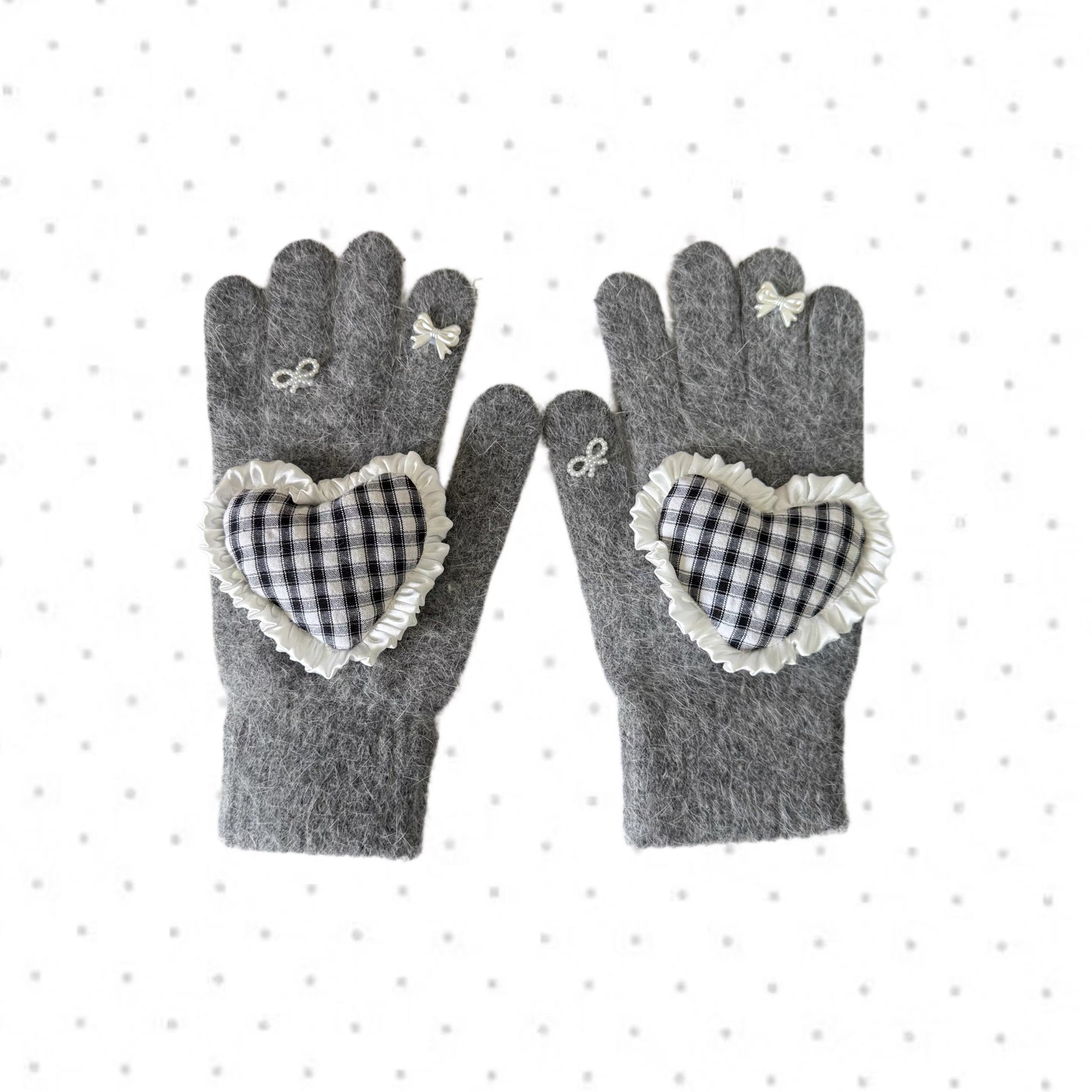 Grey knit gloves with a black and white gingham heart patch, ruffle trim, and white ribbon bows on fingers, coquette aesthetic style.