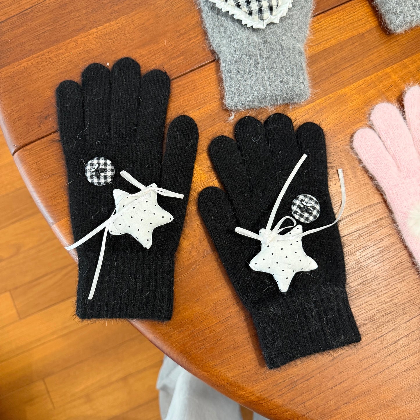 Black knit gloves with white stars and ribbon bows for Y2K grunge aesthetic.