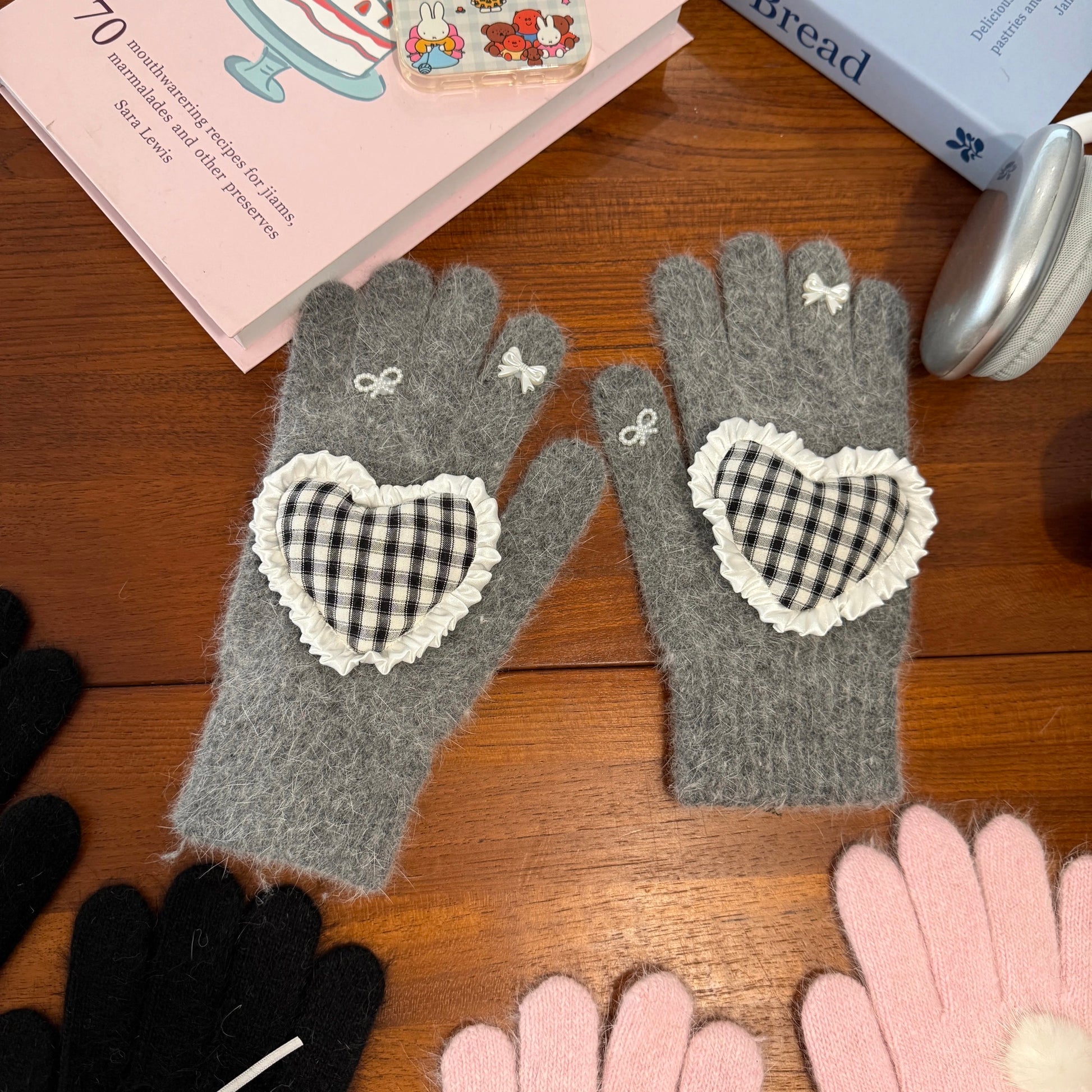 Grey knit gloves with a black and white gingham heart patch, ruffle trim, and white ribbon bows on fingers, coquette aesthetic style.