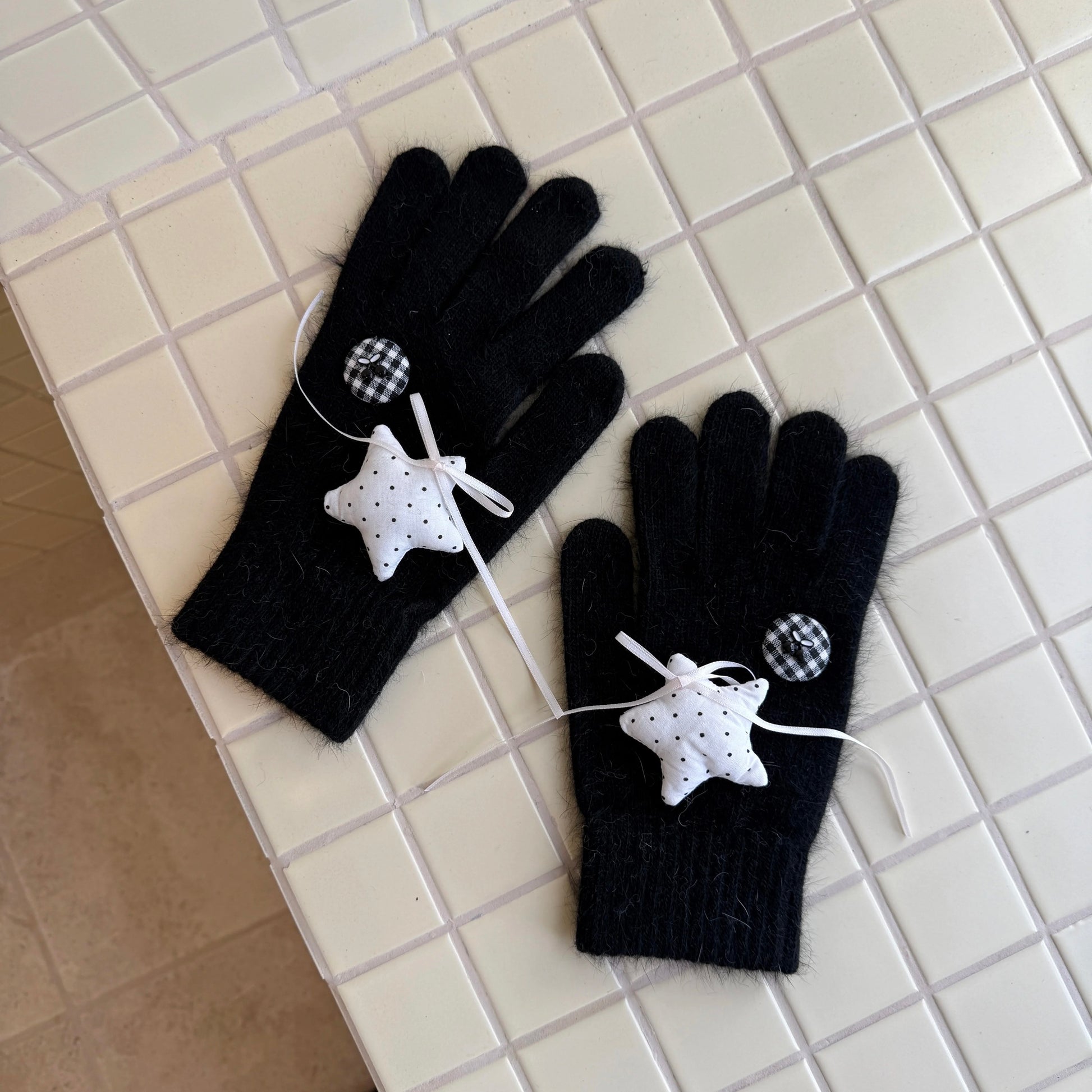 Black knit gloves with white stars and ribbon bows for Y2K grunge aesthetic.