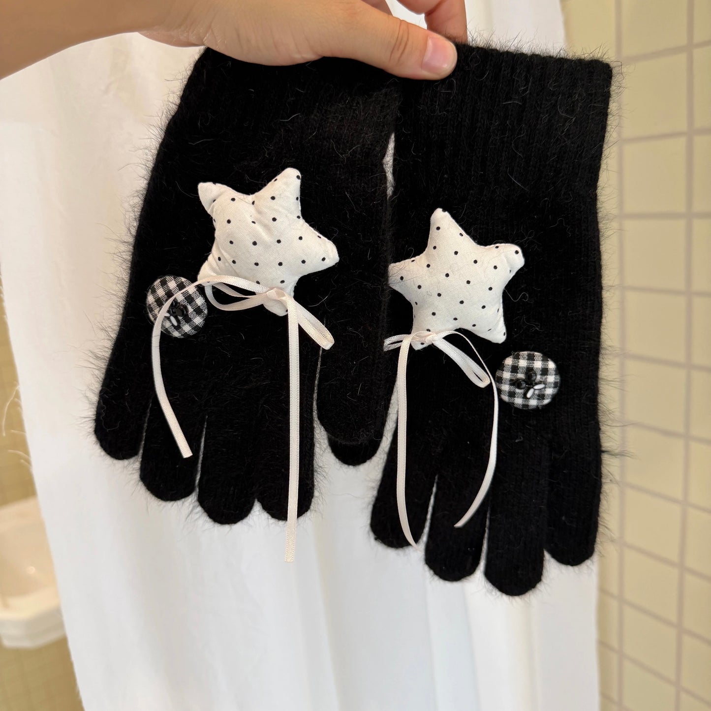 Black knit gloves with white stars and ribbon bows for Y2K grunge aesthetic.