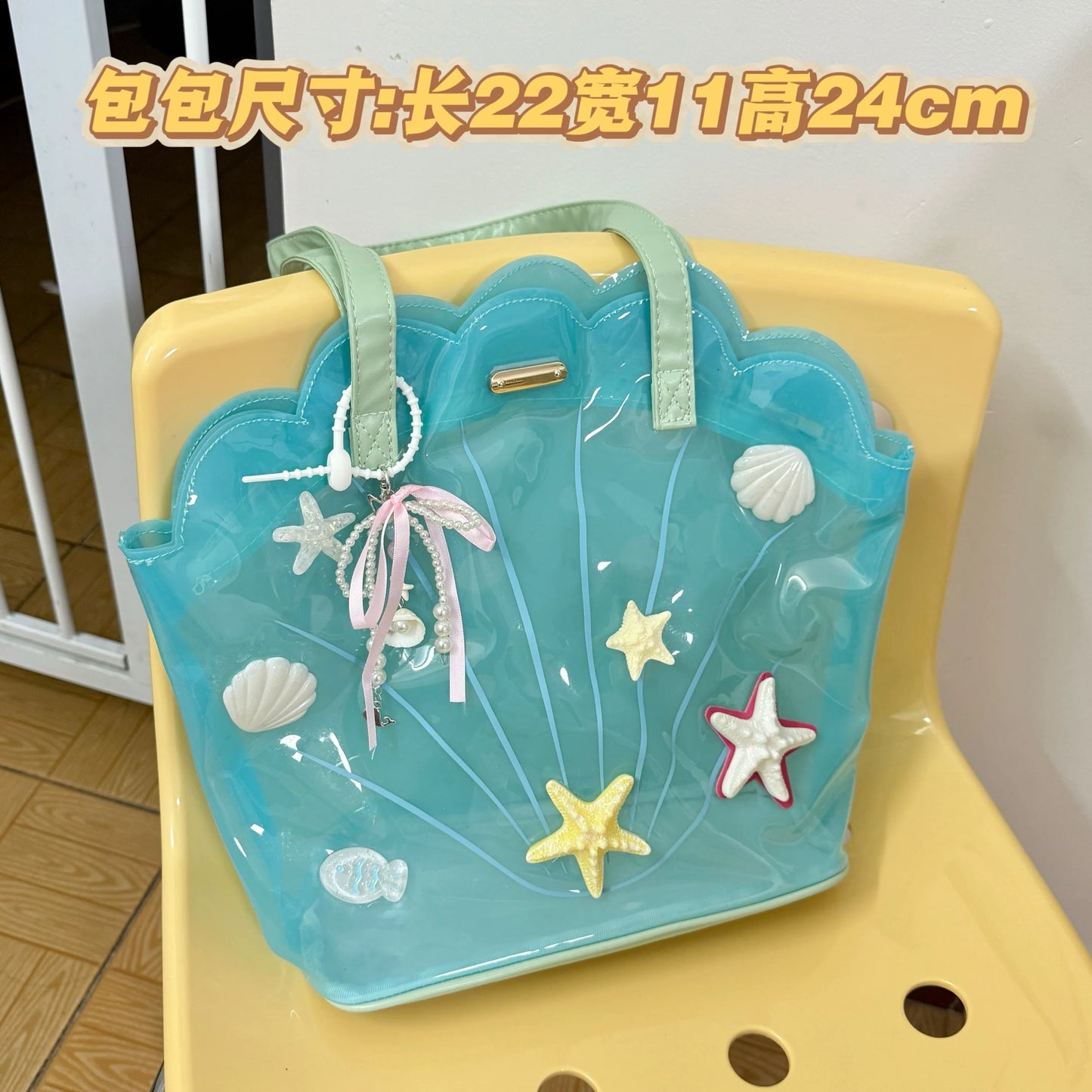 Clear aqua blue shell-shaped jelly tote bag with 3D starfish, seashells, and pearl ribbon charm.