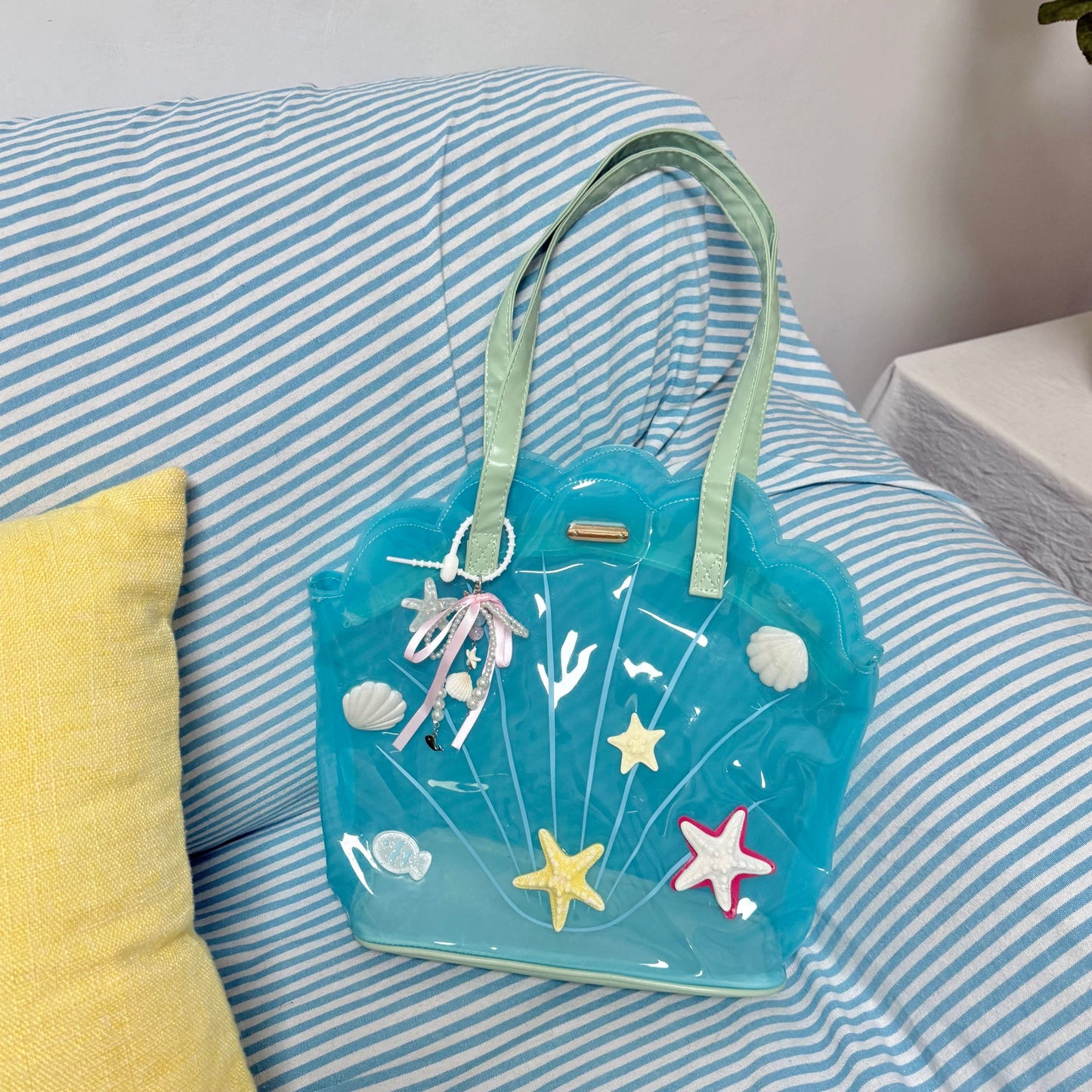 Clear aqua blue shell-shaped jelly tote bag with 3D starfish, seashells, and pearl ribbon charm.