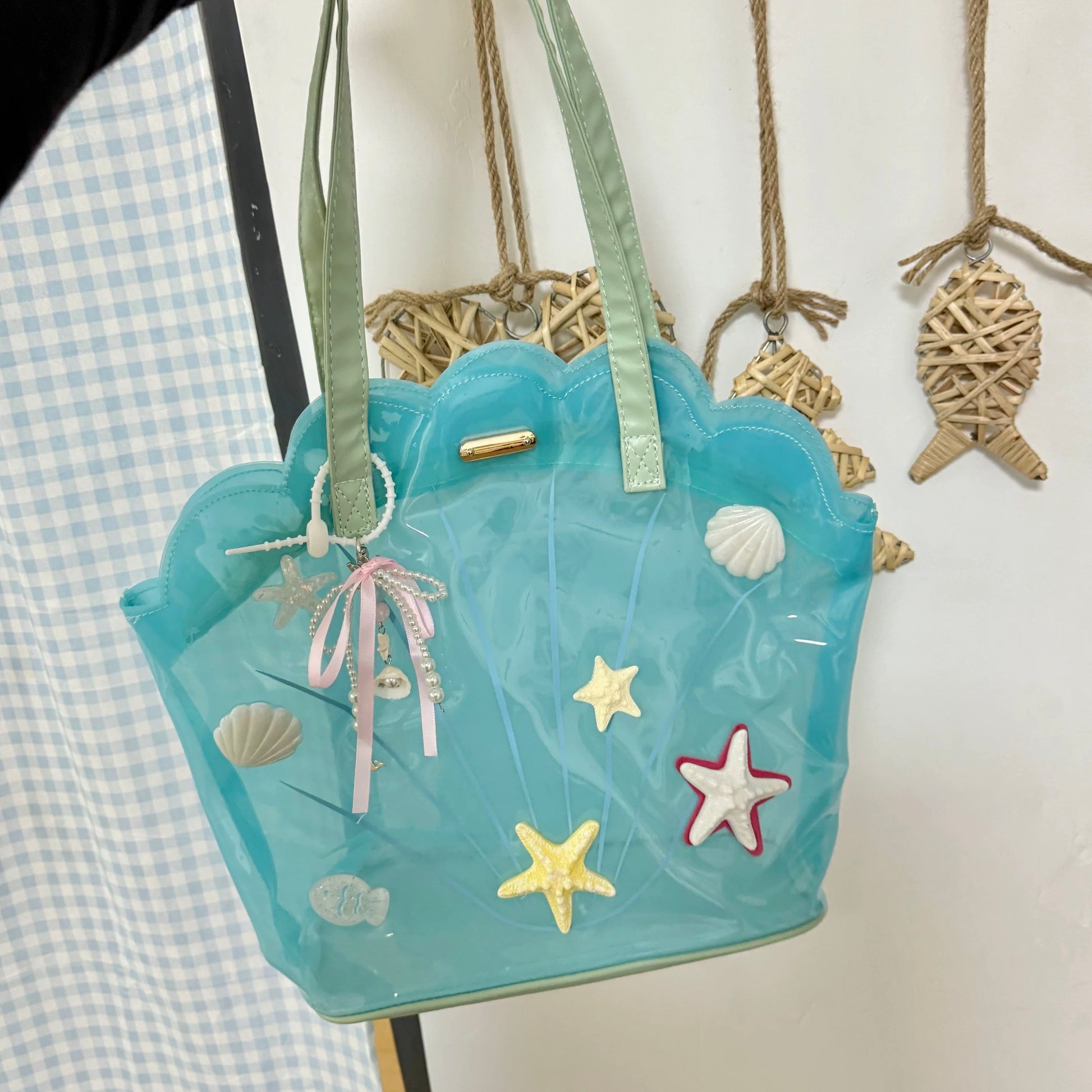 Clear aqua blue shell-shaped jelly tote bag with 3D starfish, seashells, and pearl ribbon charm.
