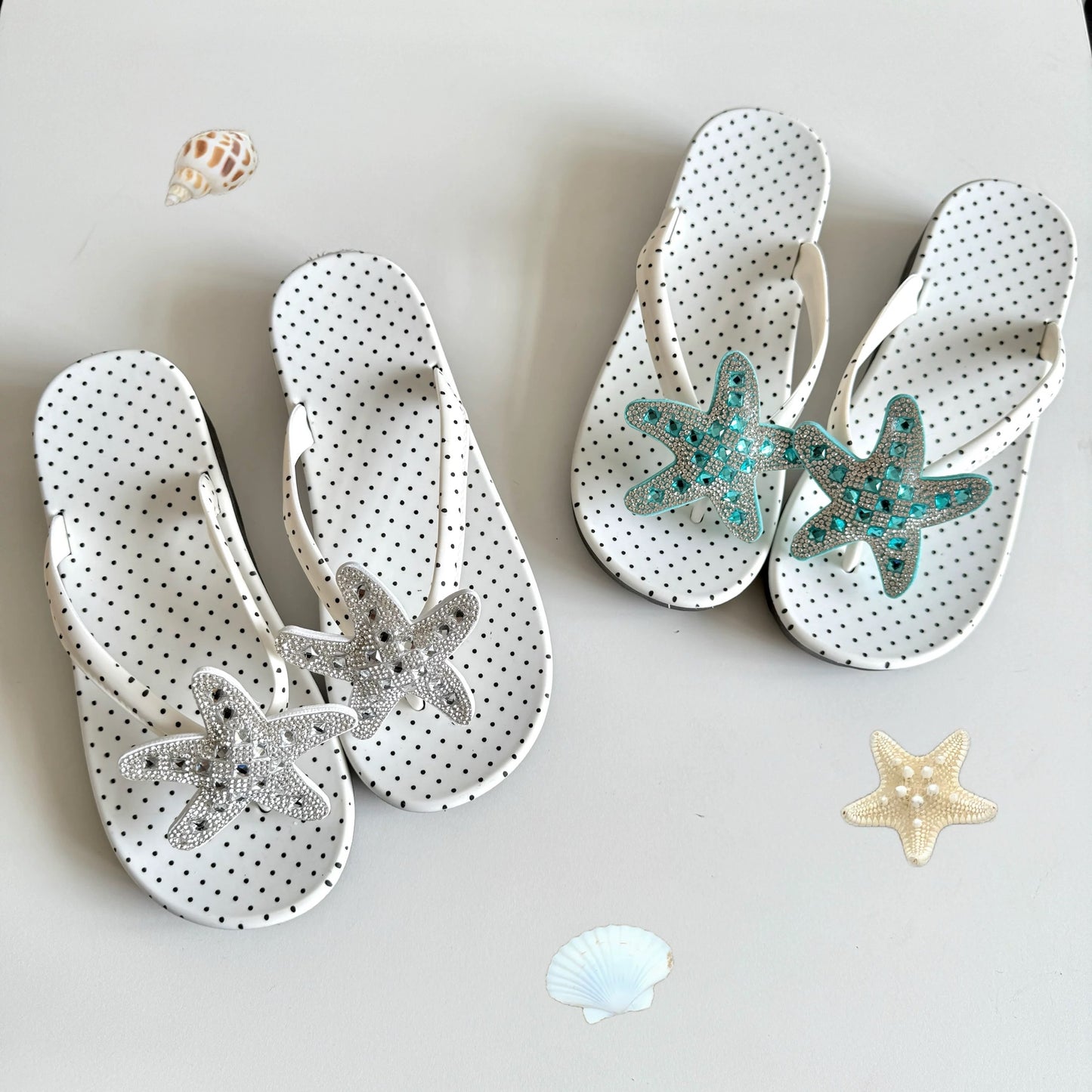 White polka dot flip flops with large jeweled turquoise starfish on sand