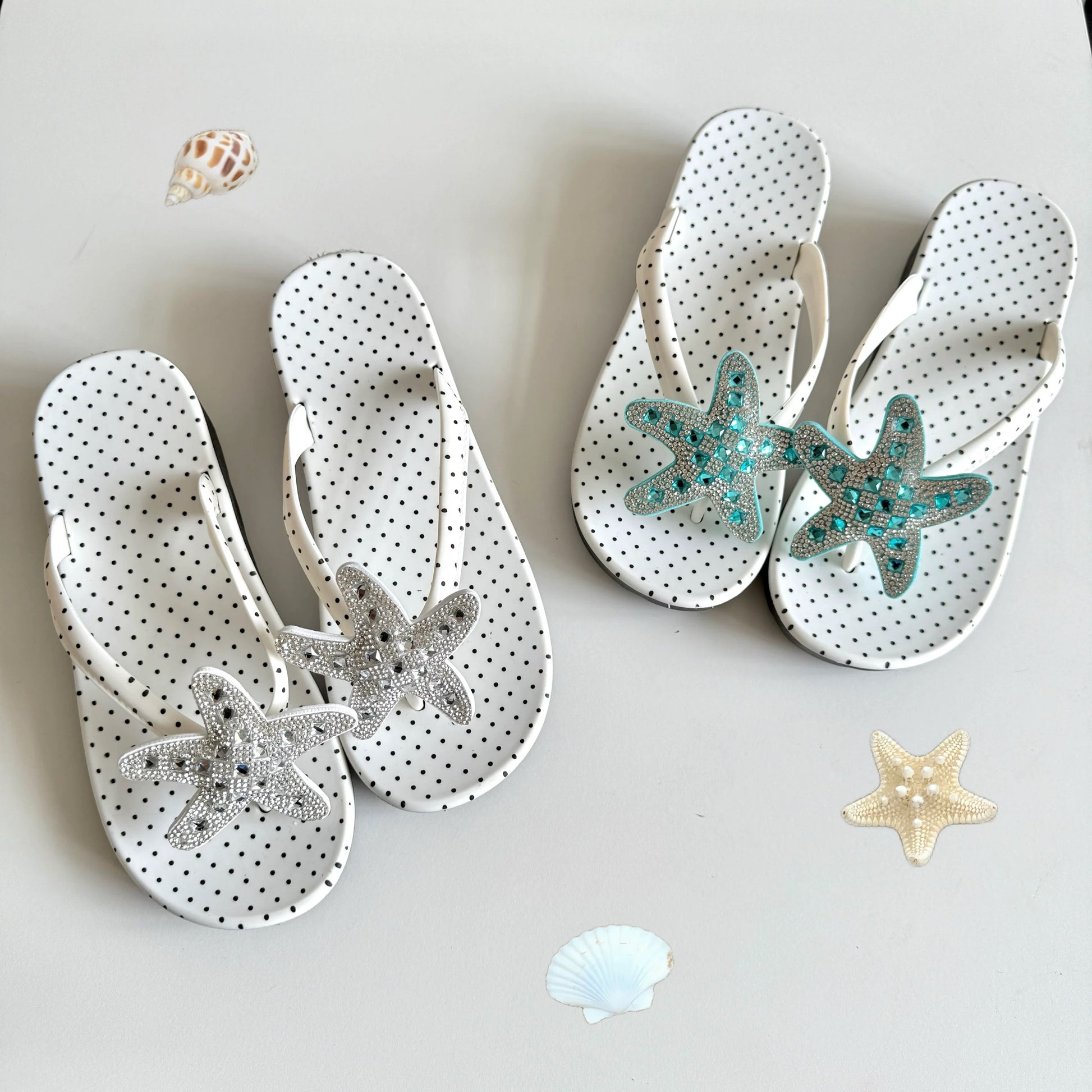 White polka dot flip flops with large jeweled turquoise starfish on sand