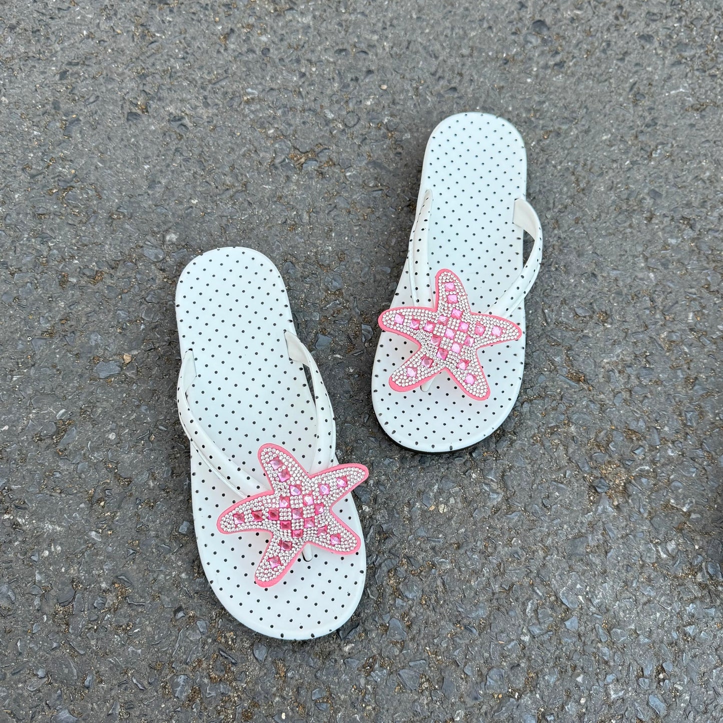 White polka dot flip flops with large jeweled turquoise starfish on sand