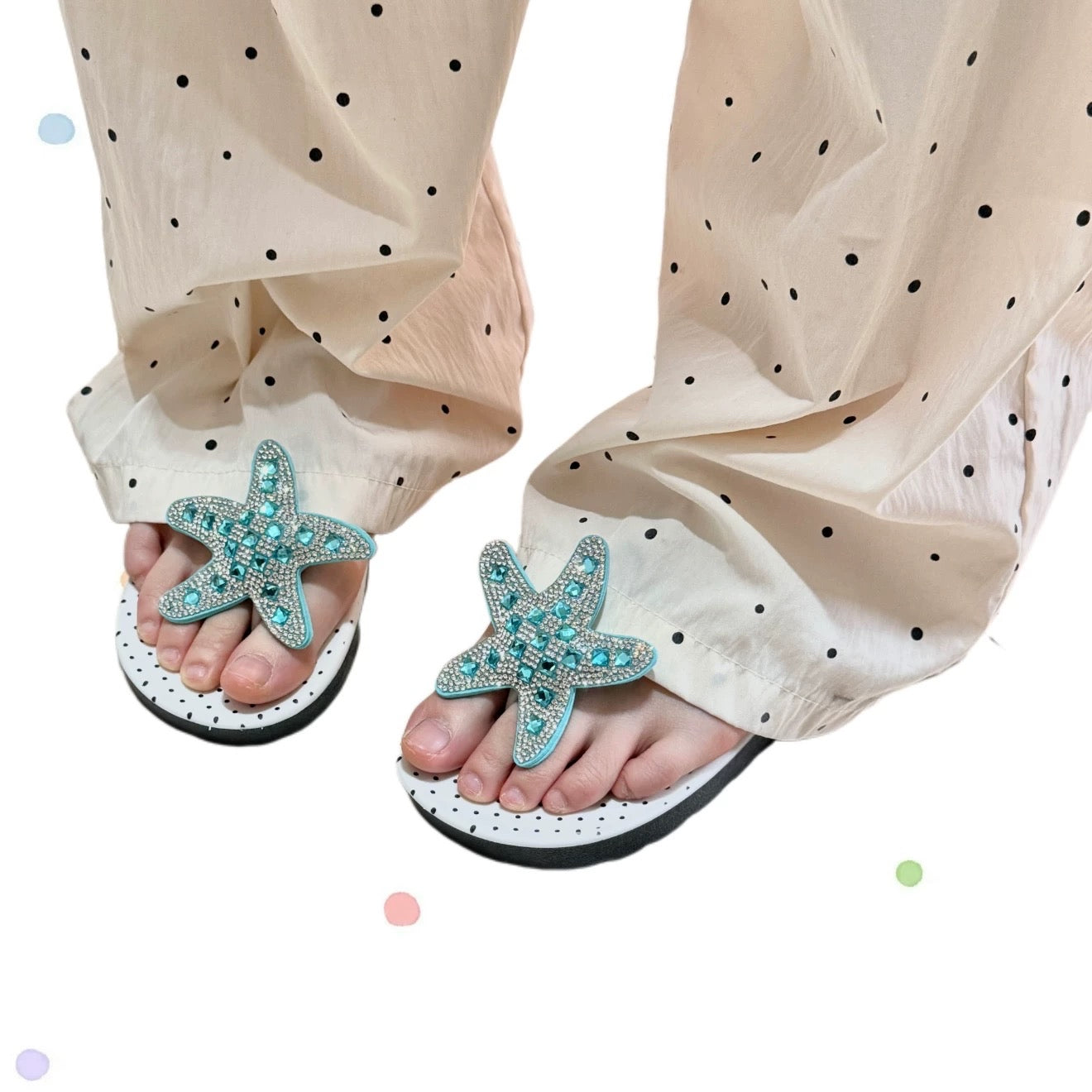 White polka dot flip flops with large jeweled turquoise starfish on sand