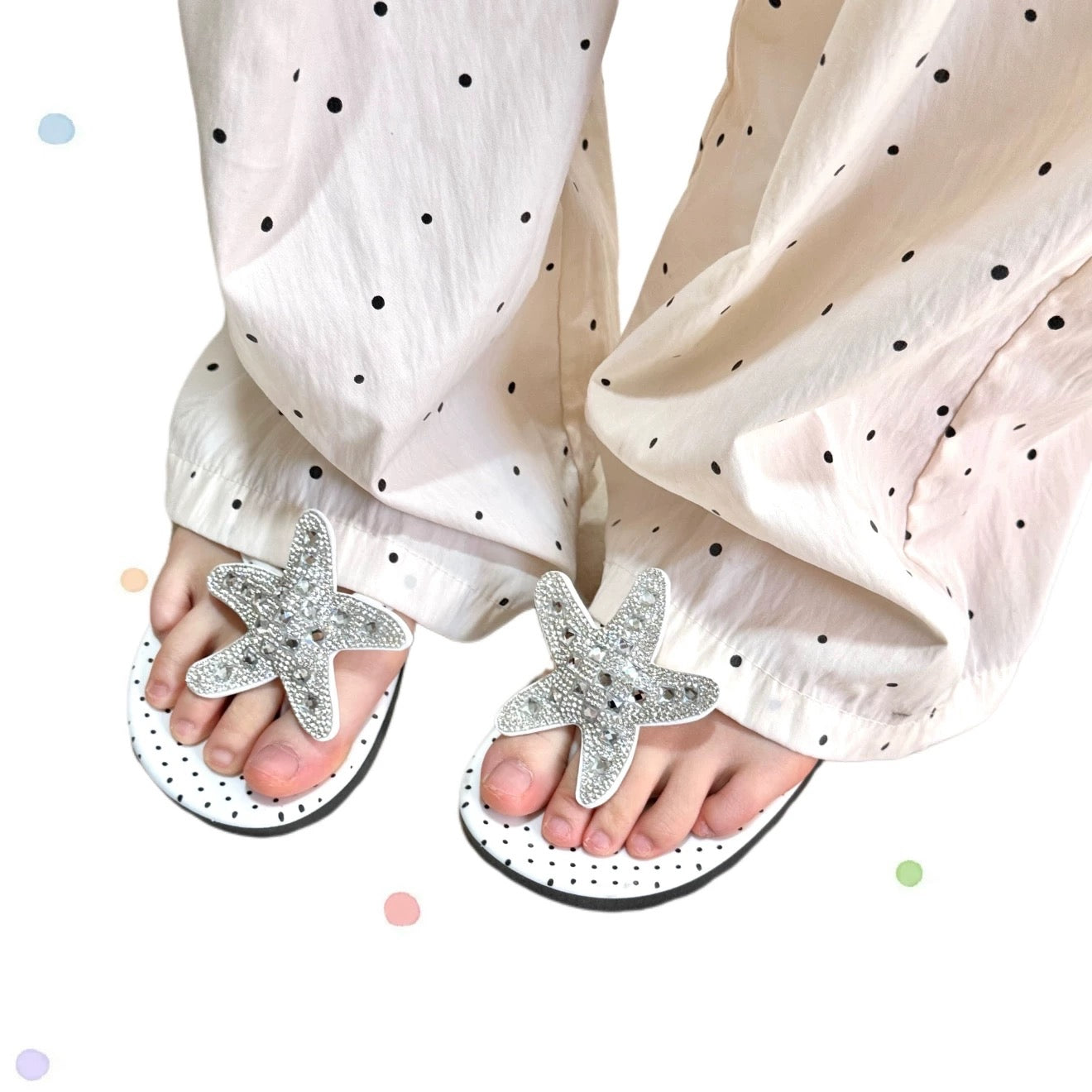 White polka dot flip flops with large jeweled turquoise starfish on sand
