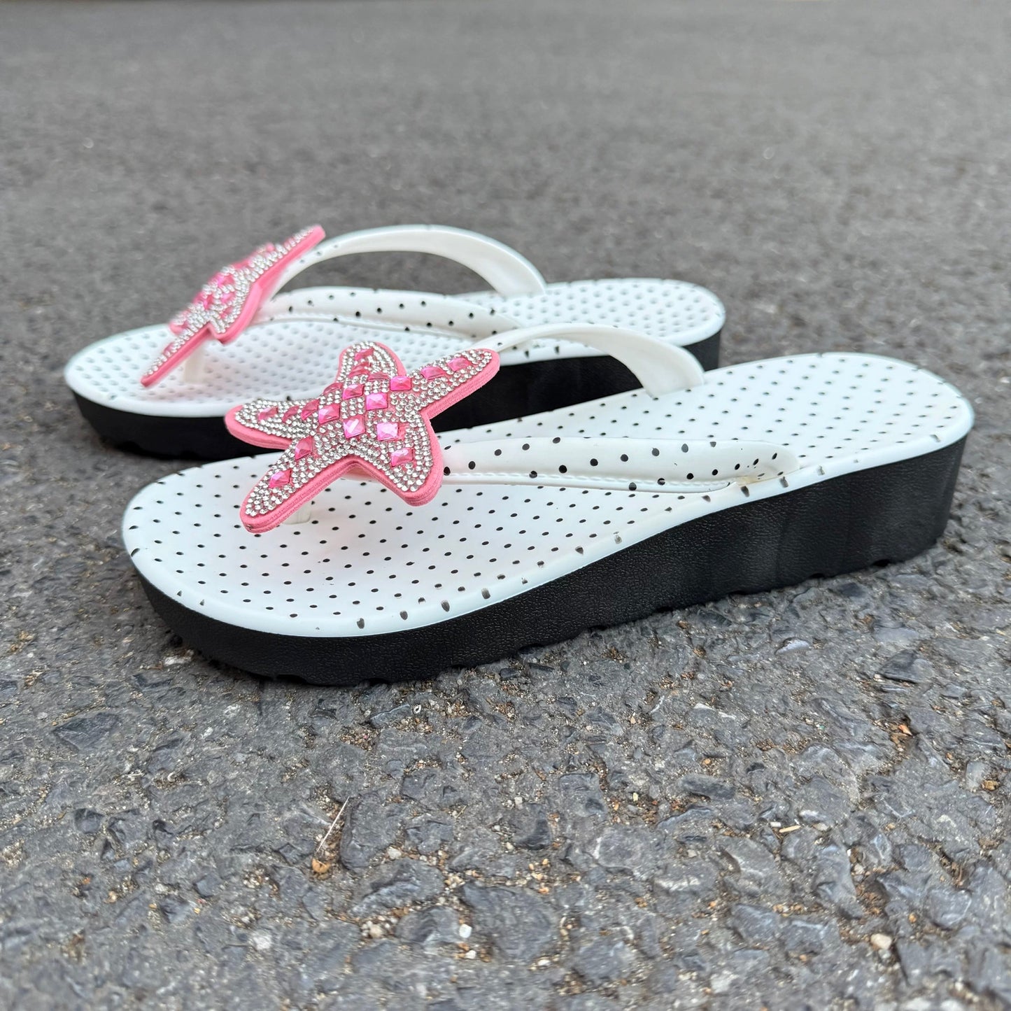 White polka dot flip flops with large jeweled turquoise starfish on sand