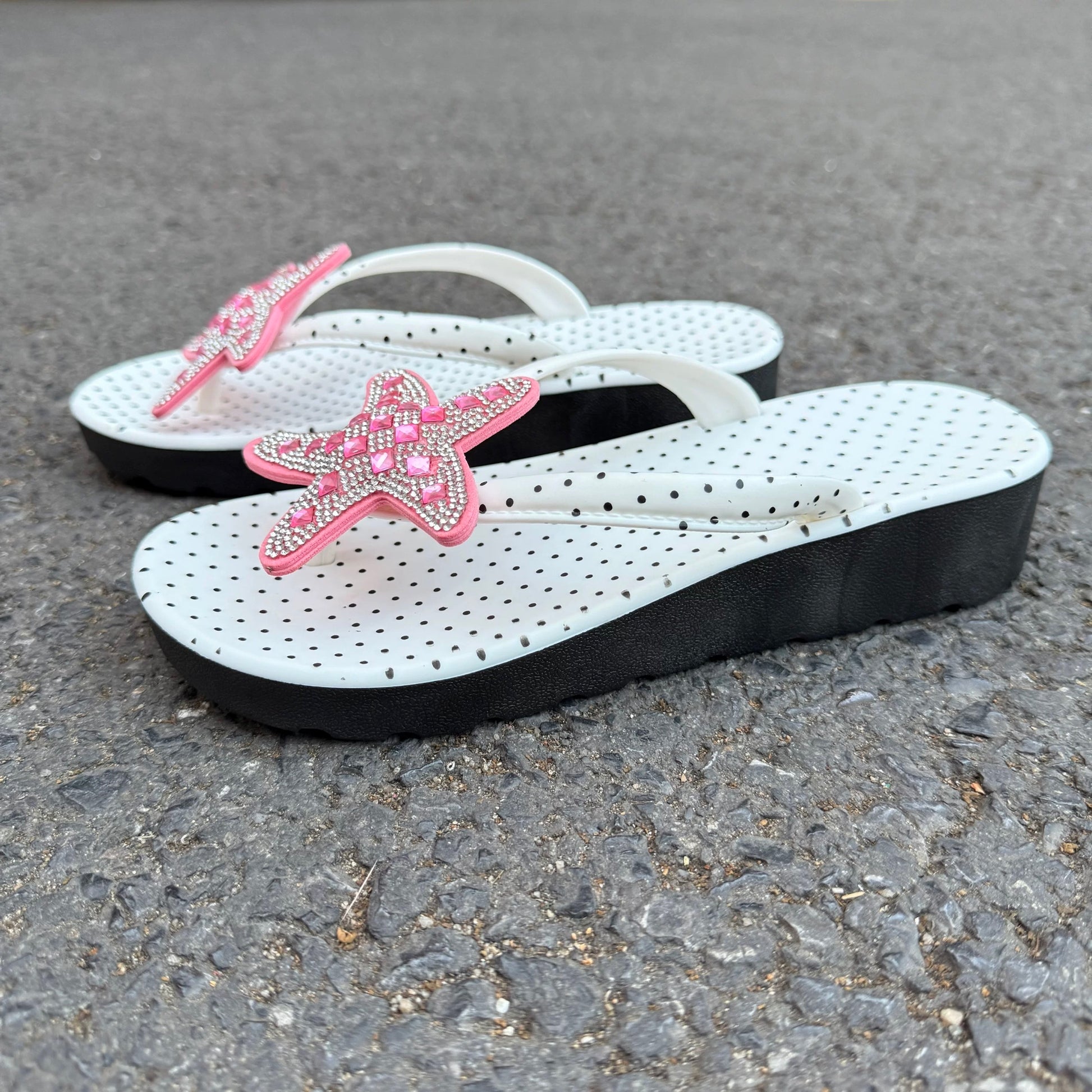 White polka dot flip flops with large jeweled turquoise starfish on sand
