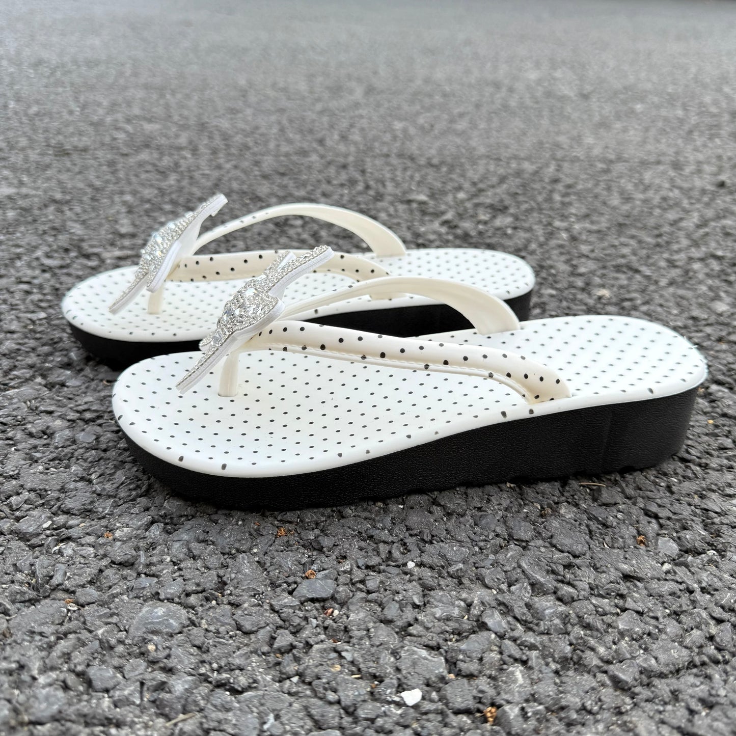 White polka dot flip flops with large jeweled turquoise starfish on sand