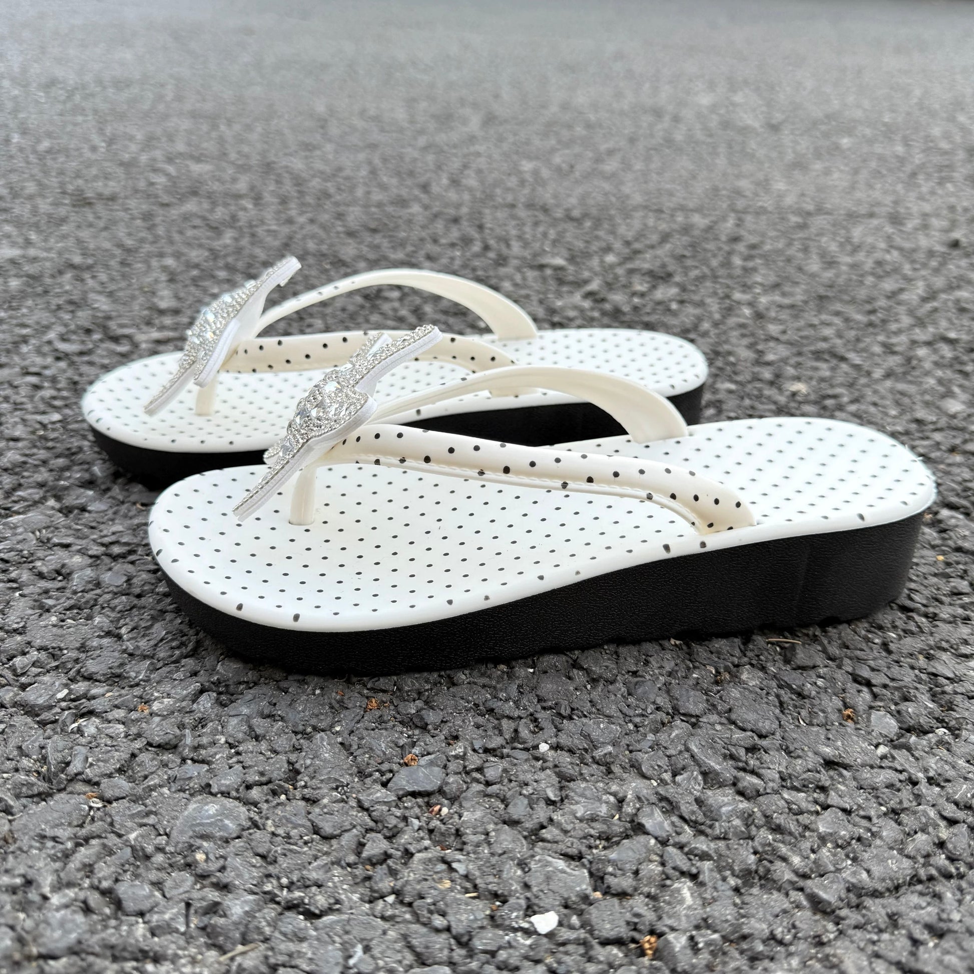 White polka dot flip flops with large jeweled turquoise starfish on sand