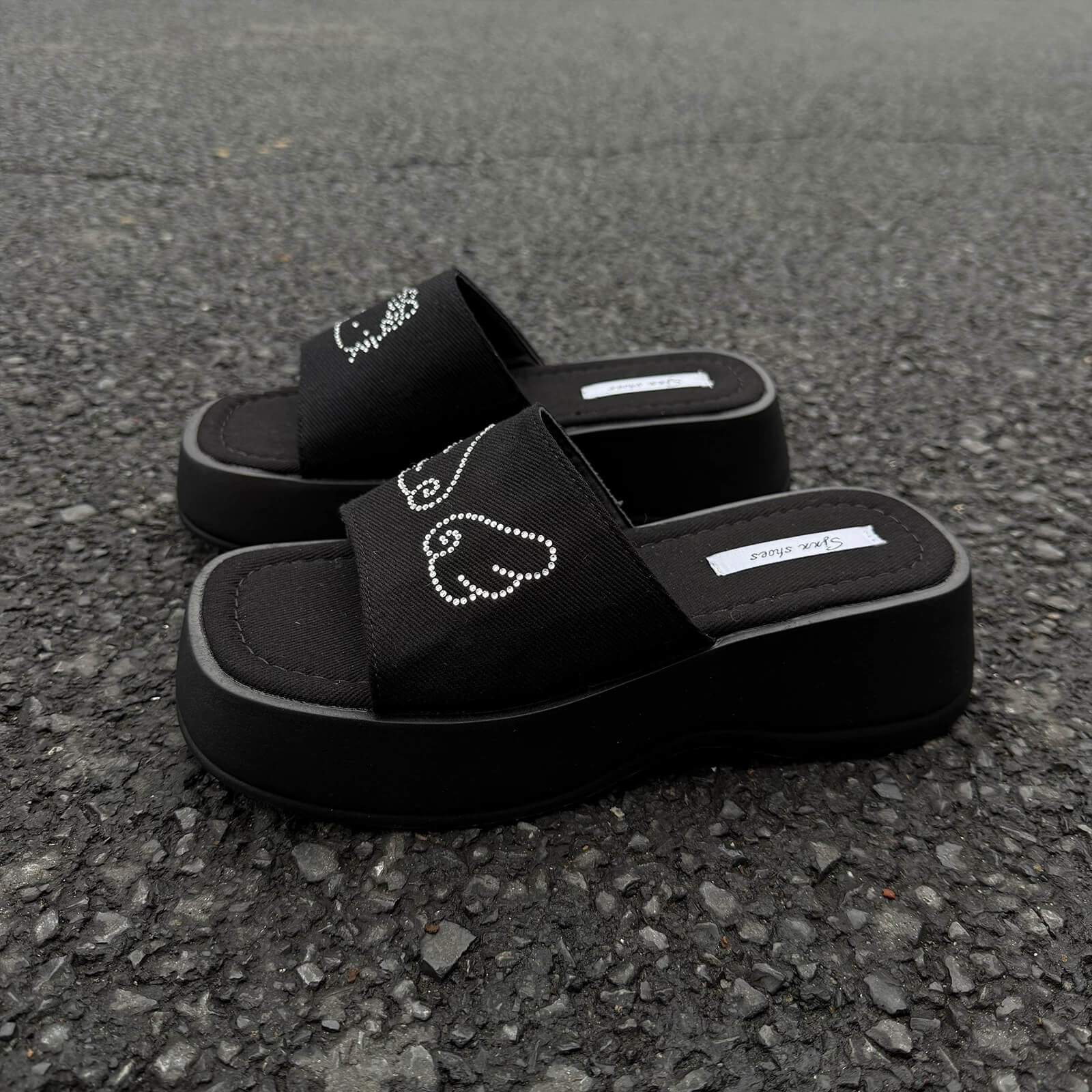 Black platform slide sandals with rhinestone cartoon cat design and chunky sole