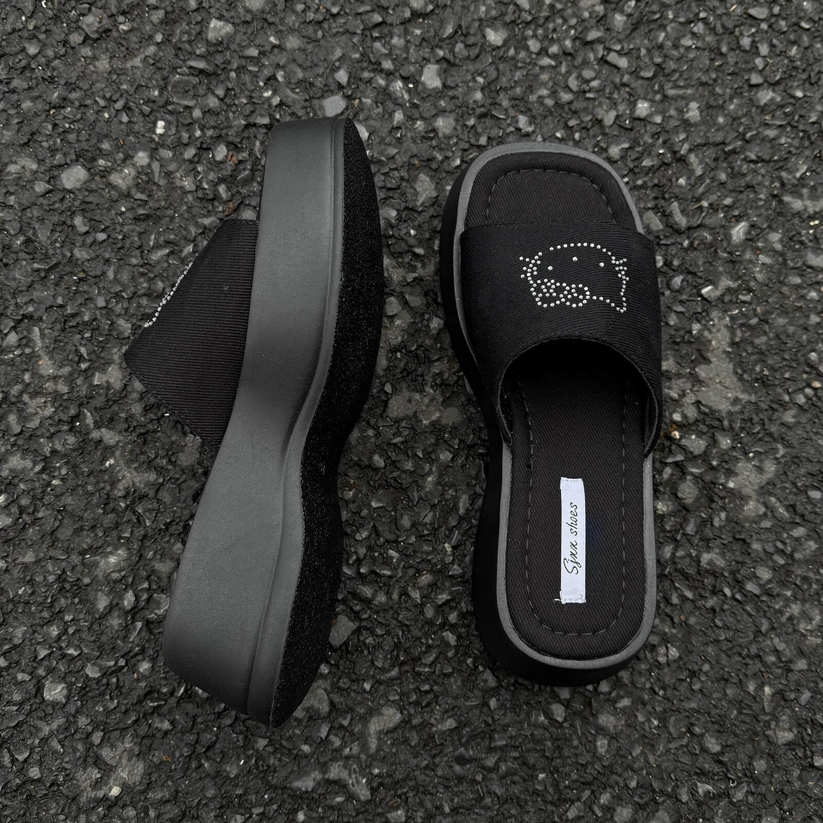 Black platform slide sandals with rhinestone cartoon cat design and chunky sole