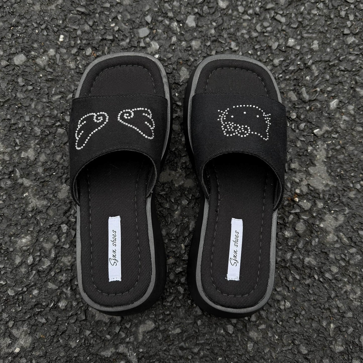Black platform slide sandals with rhinestone cartoon cat design and chunky sole