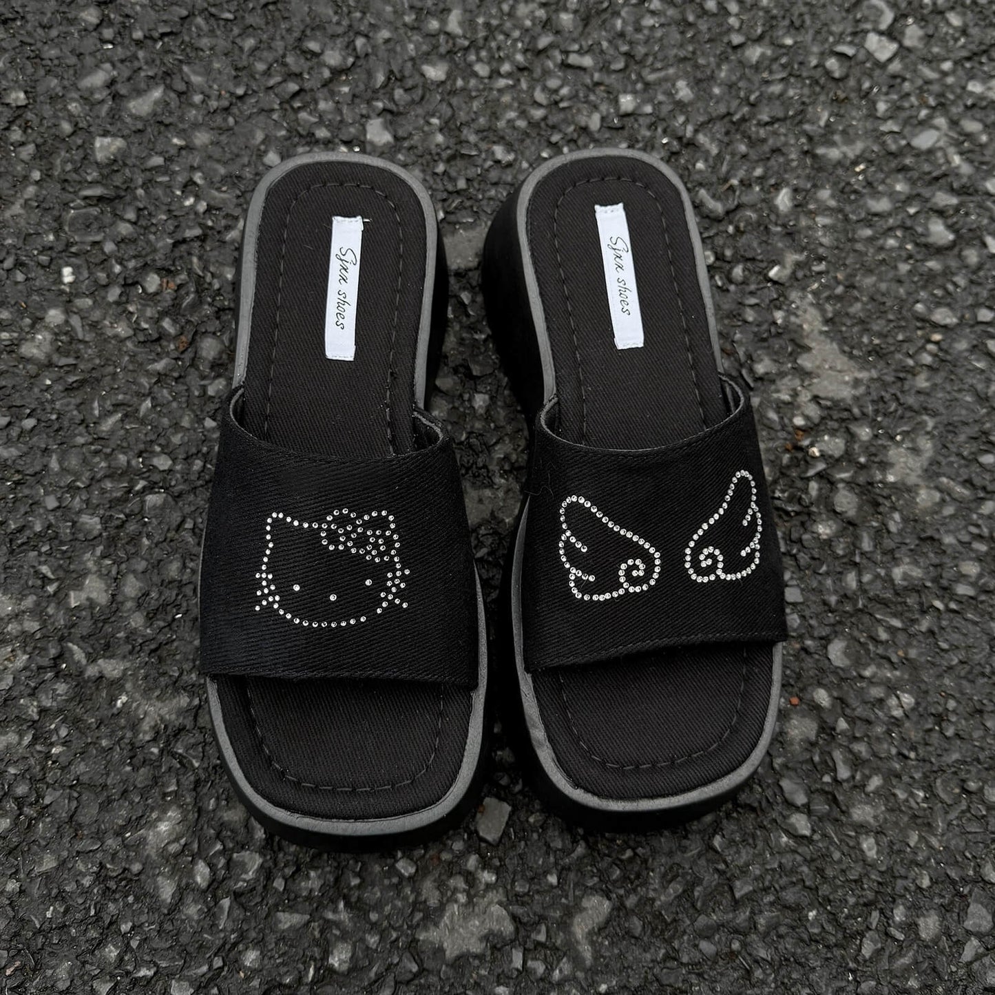 Black platform slide sandals with rhinestone cartoon cat design and chunky sole