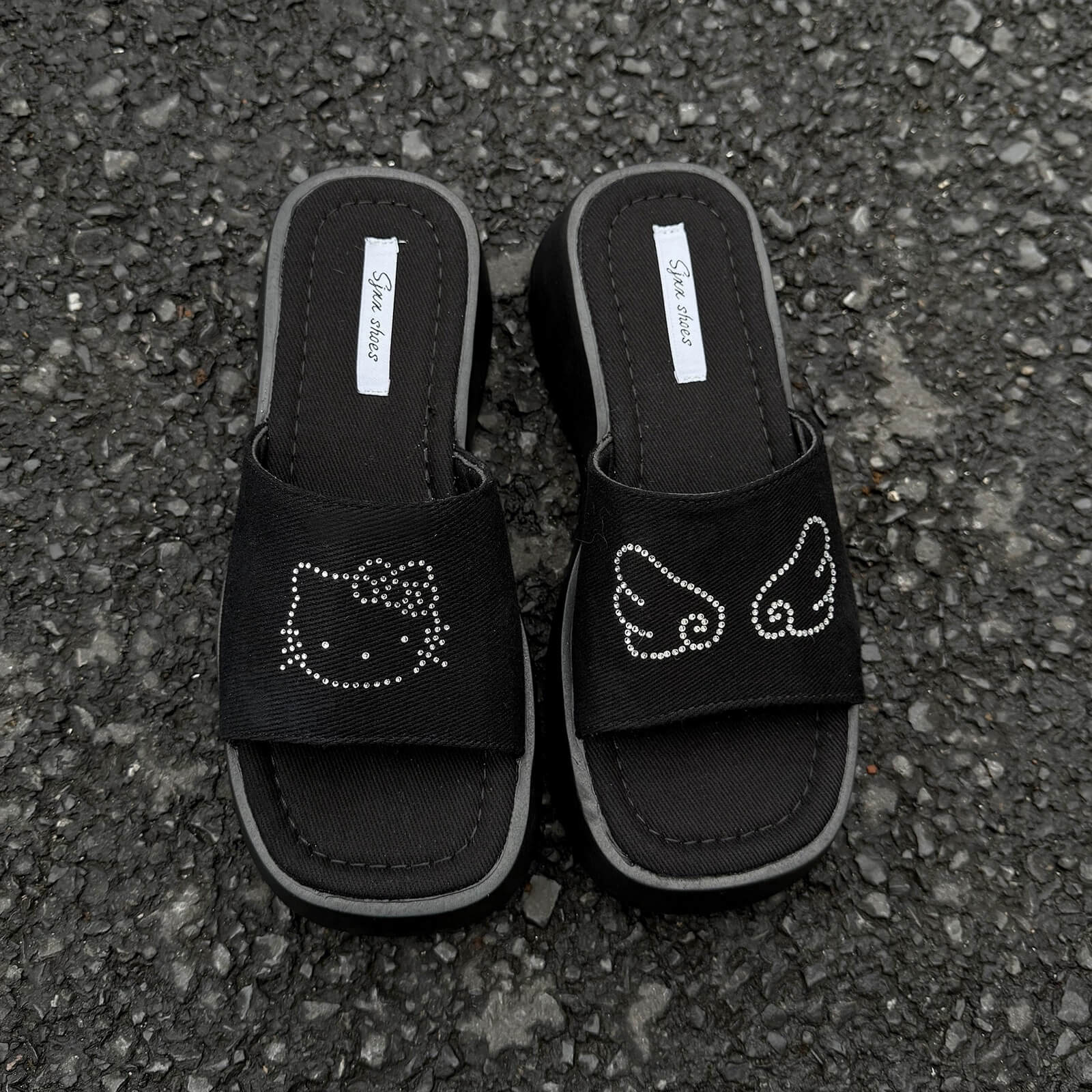 Black platform slide sandals with rhinestone cartoon cat design and chunky sole