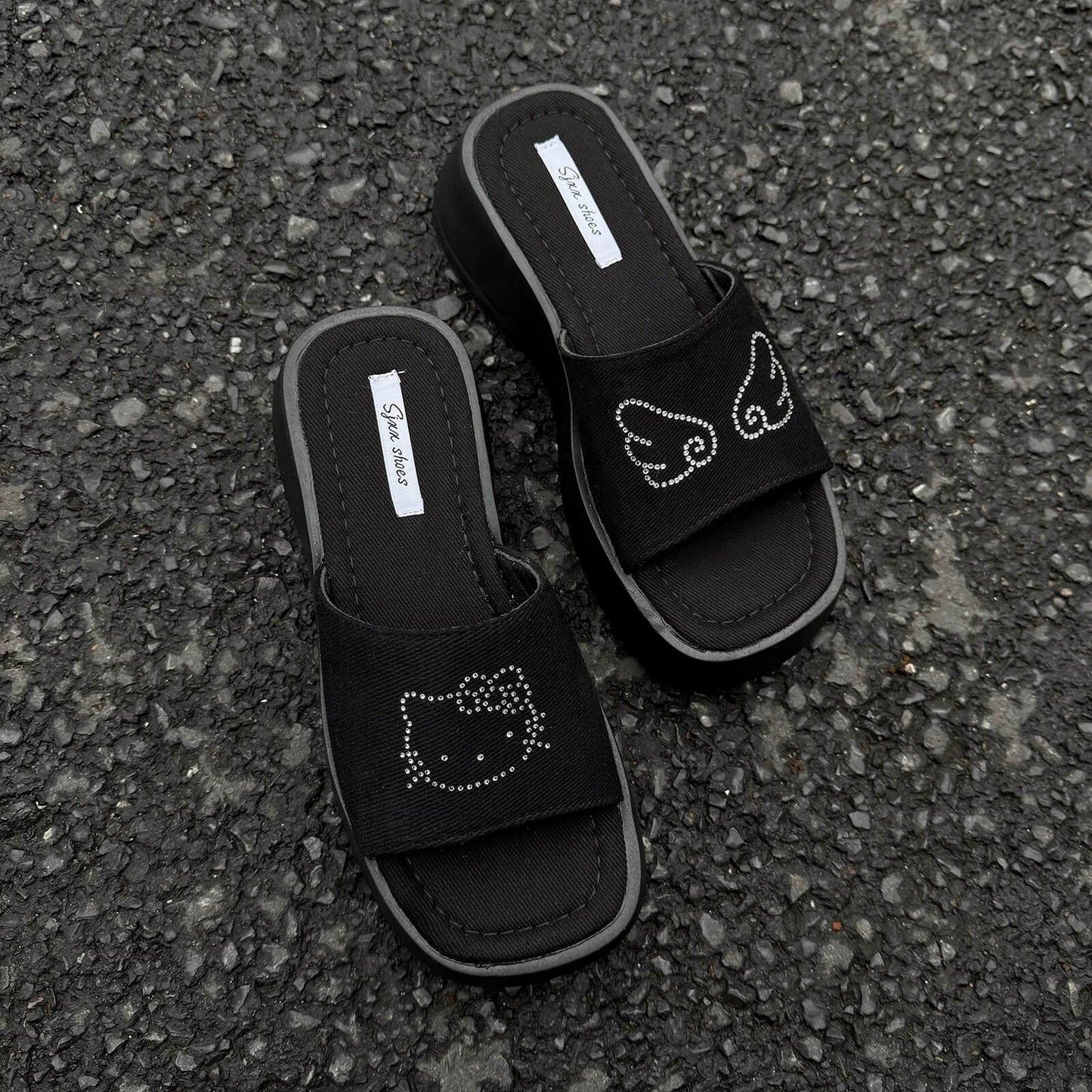 Black platform slide sandals with rhinestone cartoon cat design and chunky sole