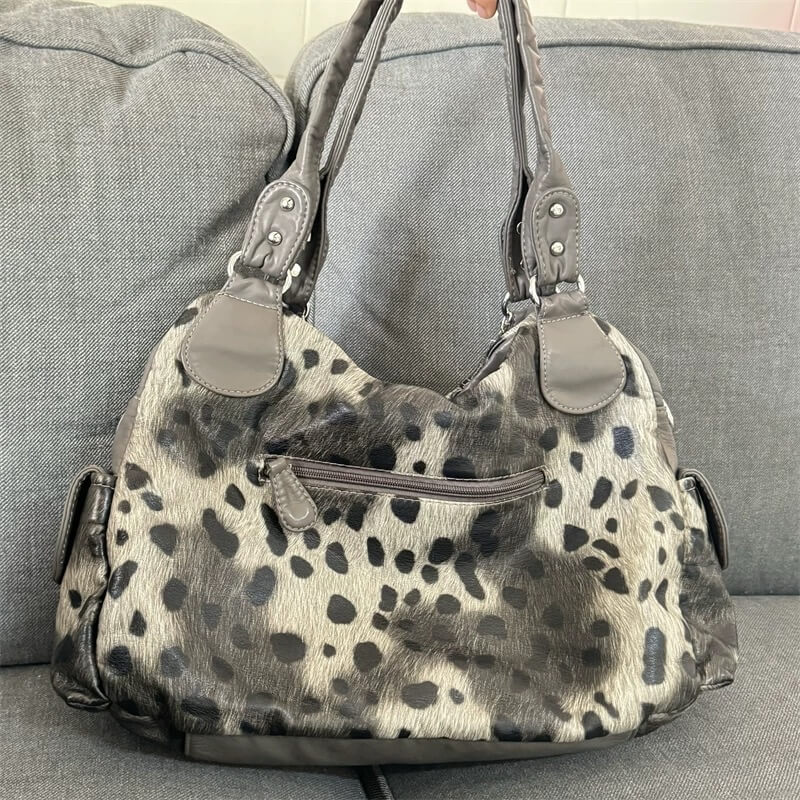 Leopard print handbag with chain detail on a gray background