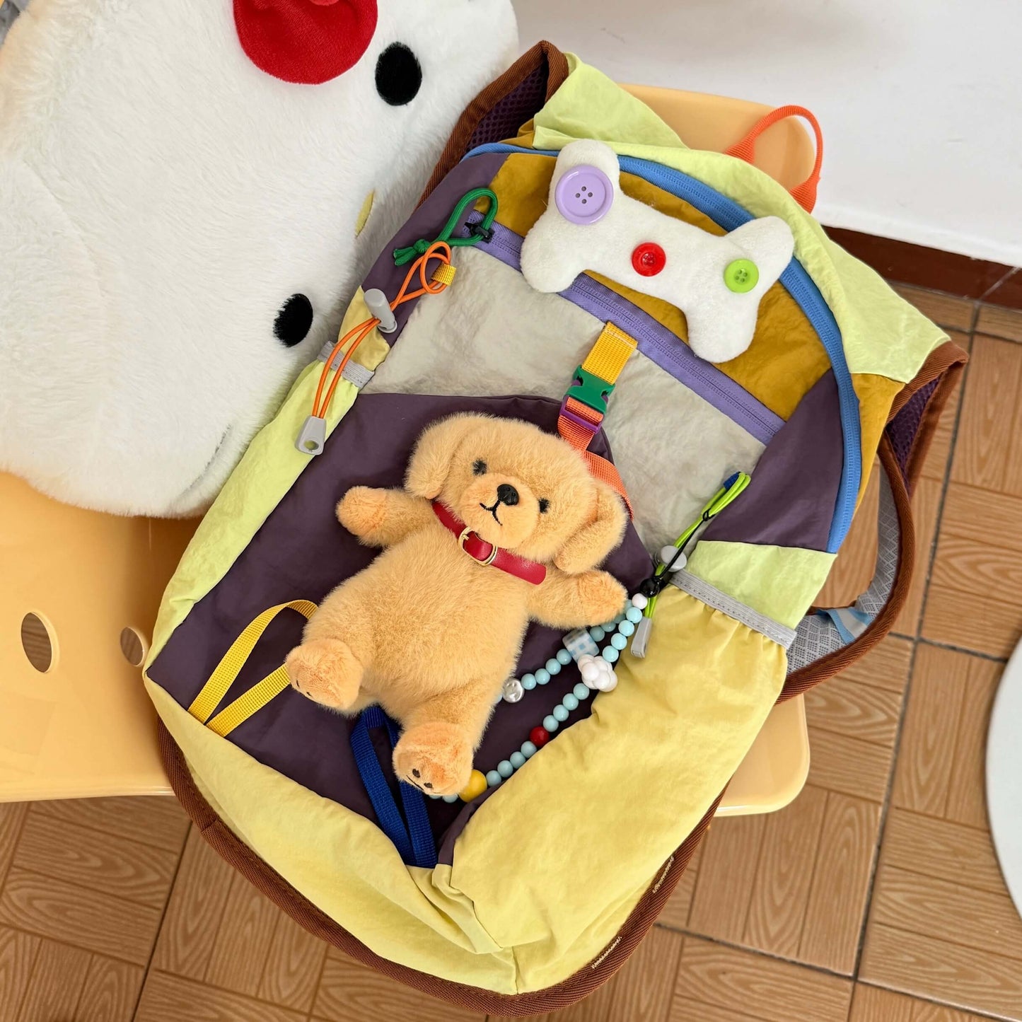 Baby toy with teddy bear and colorful elements on a wooden floor