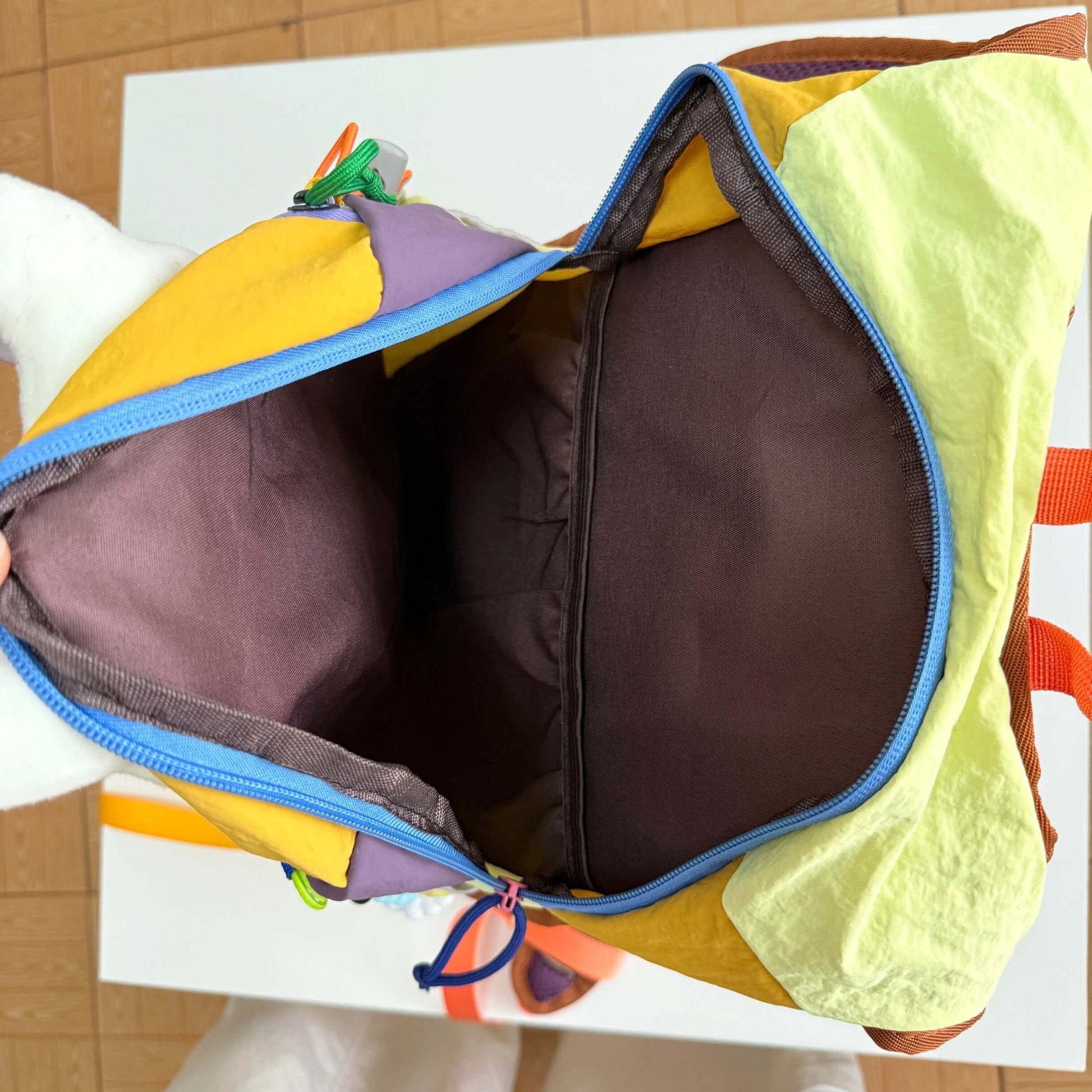Colorful children's bag with a brown interior on a white surface.